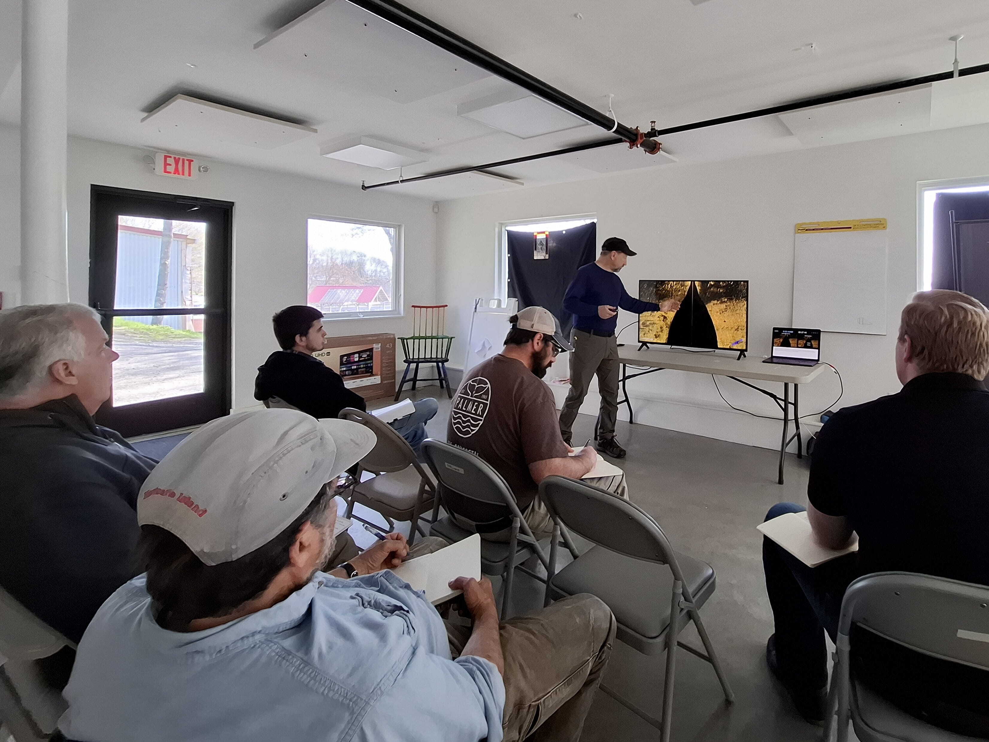 Vince Capone points to a screen displaying side-scan sonar imagery in a classroom setting